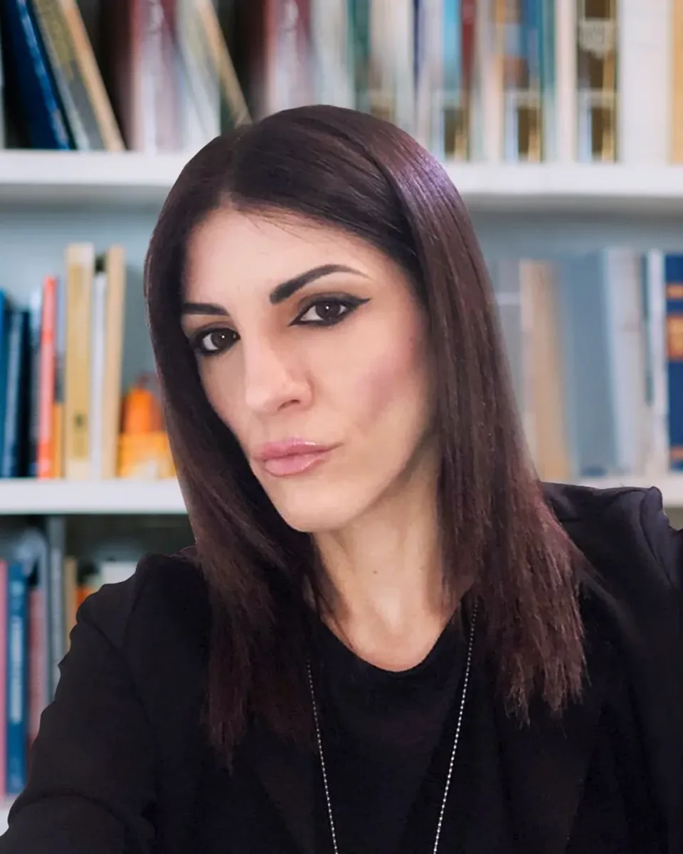 L'avvocata Maria Elisa Guttieri ritratta davanti agli scaffali di volumi giuridici dello studio
